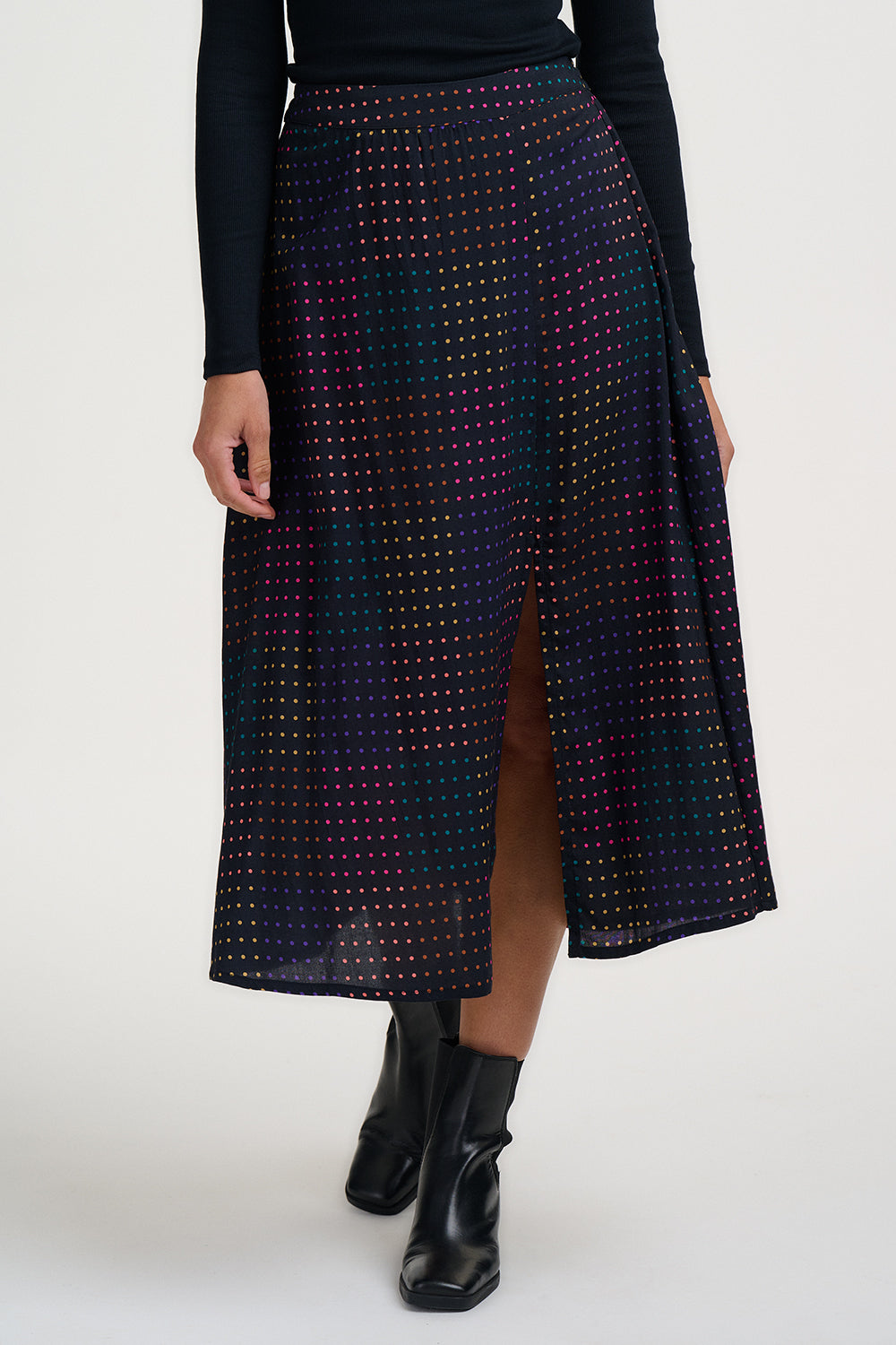 Person wearing a patterned skirt with a plain background