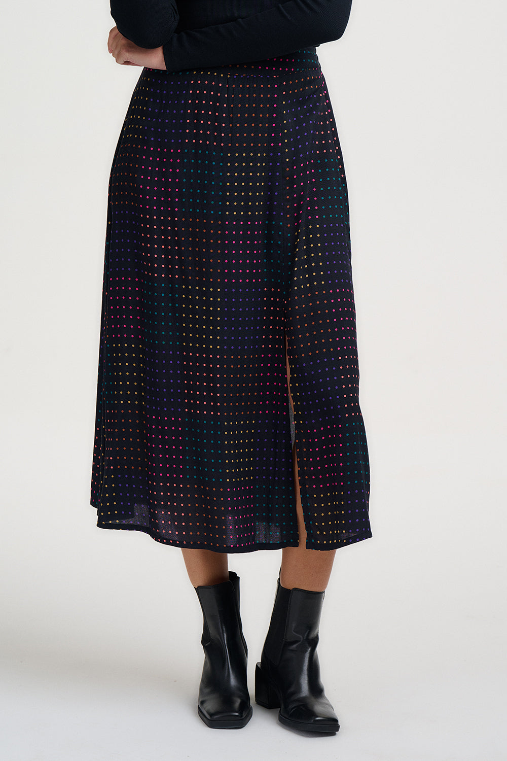 Person wearing a patterned skirt with a plain background