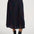 Person wearing a patterned skirt with a plain background