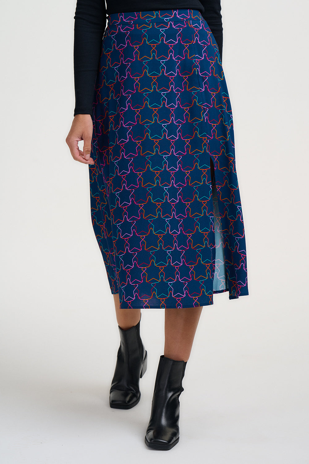 Person wearing a blue patterned skirt with black boots on a white background
