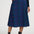 Person wearing a blue patterned skirt with black top and boots on a white background