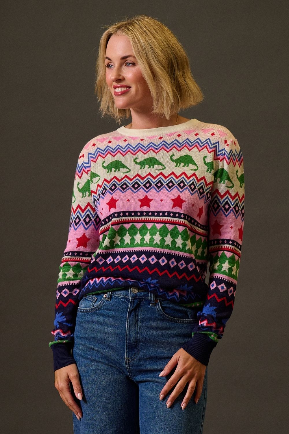 Woman wearing a colorful patterned sweater against a plain background