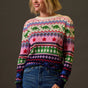 Woman wearing a colorful patterned sweater against a plain background