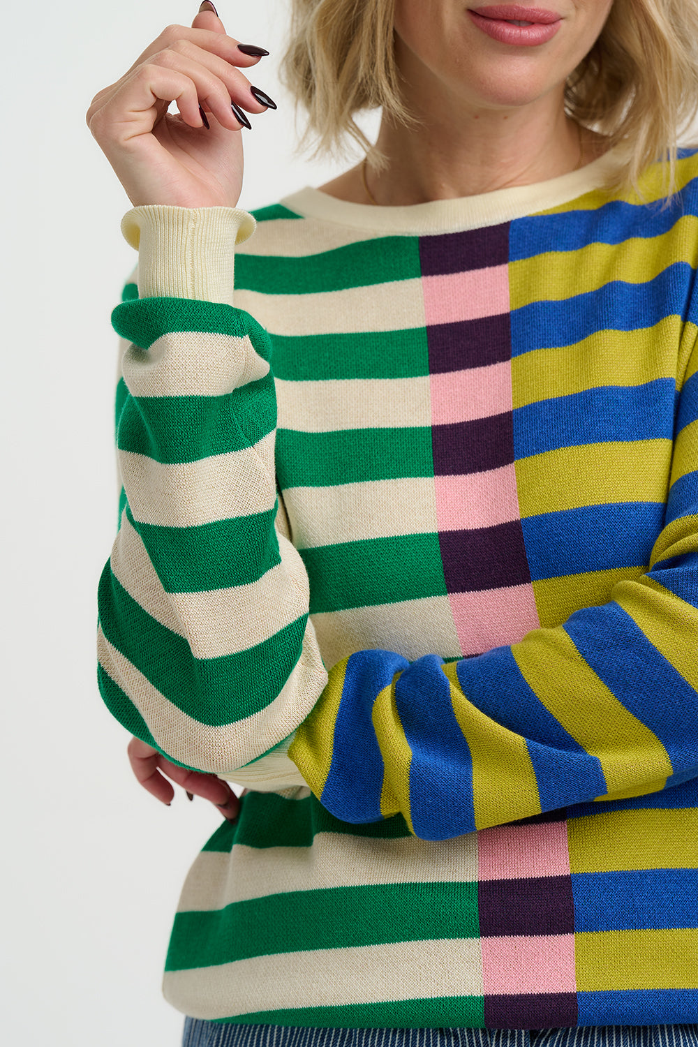 Colorful striped sweater worn by a person on a white background