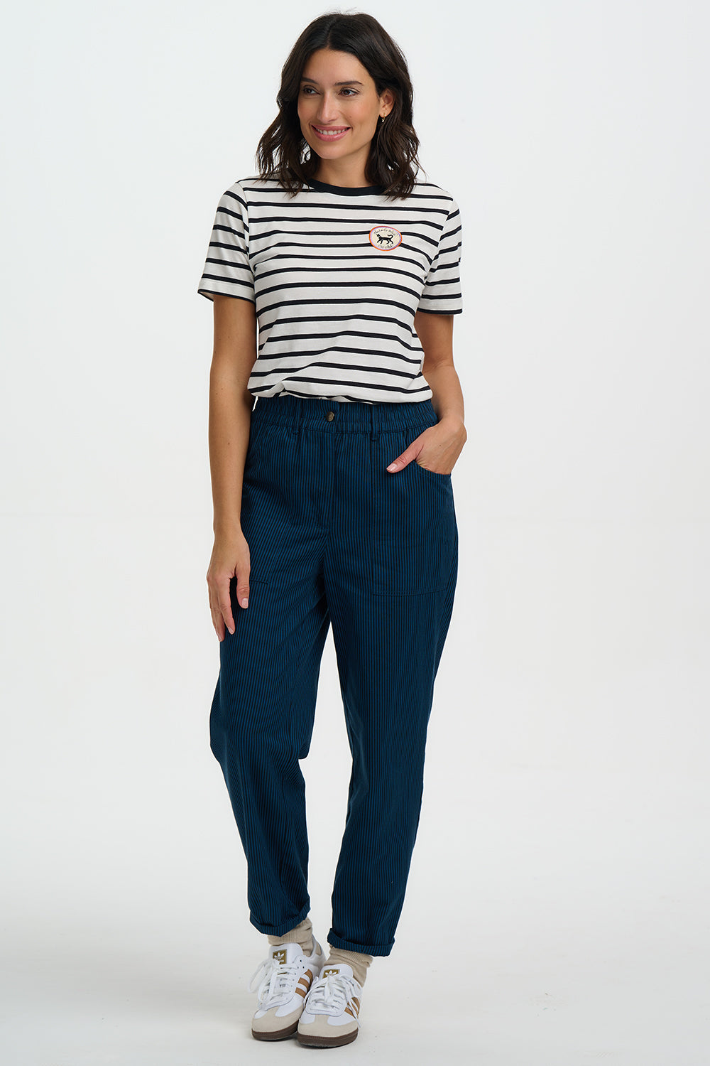 Woman wearing a striped shirt and blue pants on a white background