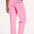 A model wearing pink Rowan trousers with a triple star pattern, paired with a striped top, standing against a white background.