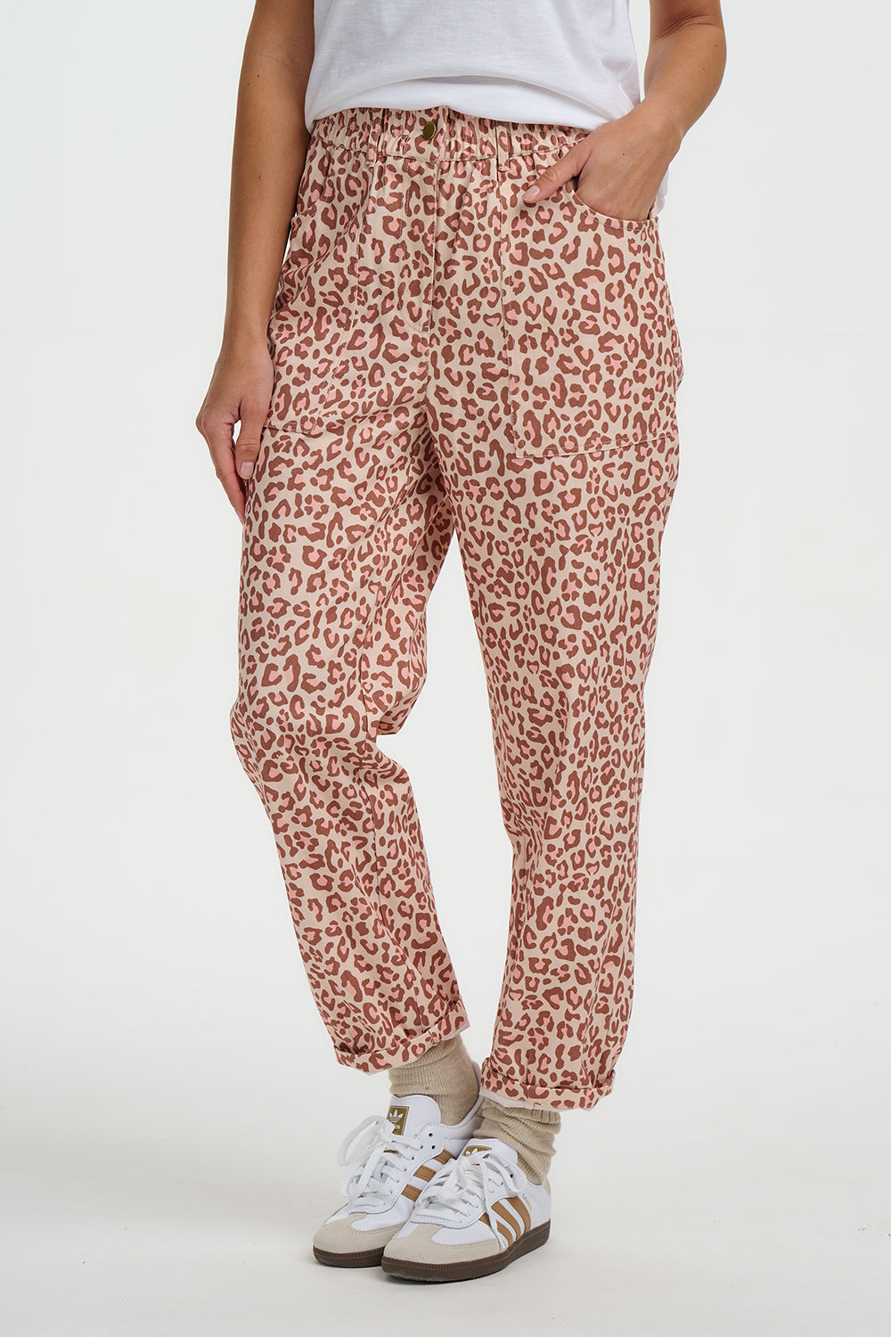 Person wearing leopard print pants on a white background