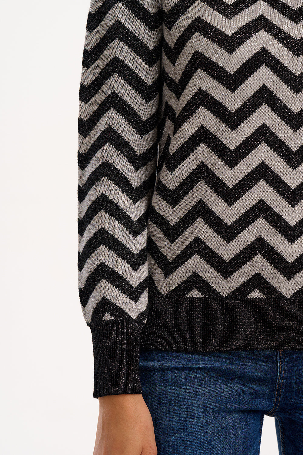 Sweater with a zigzag pattern worn by a person, with a plain background