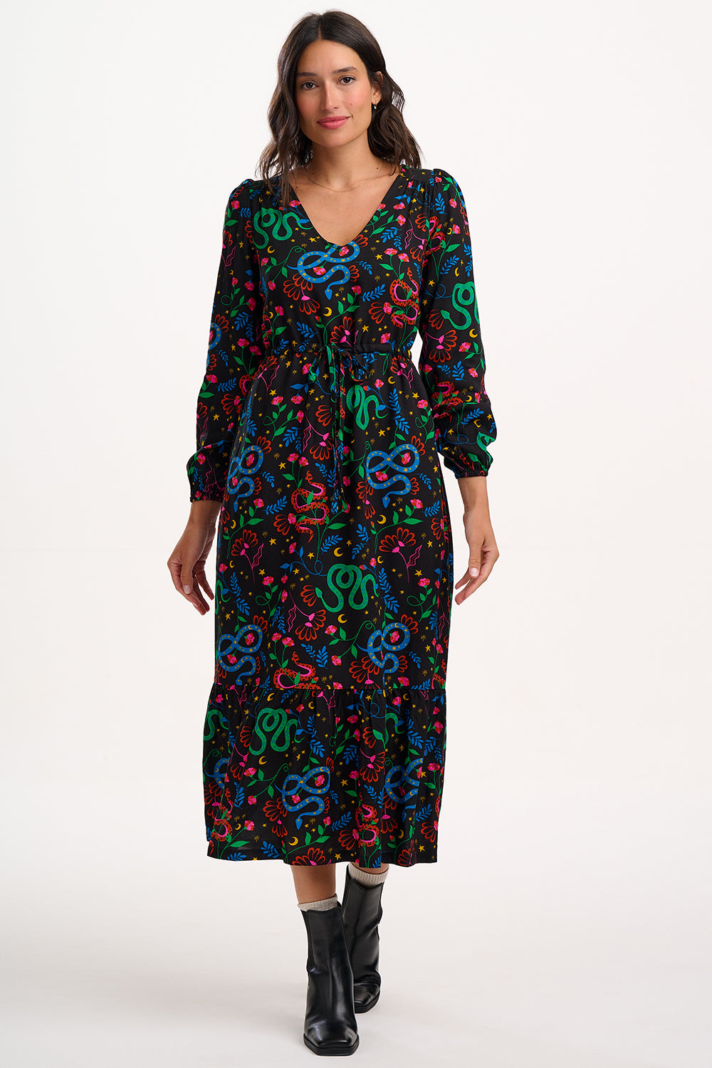 Woman wearing a colorful snake pattern dress on a white background