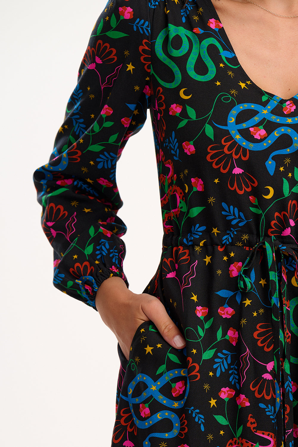 Colorful snake and floral patterned dress on a plain background