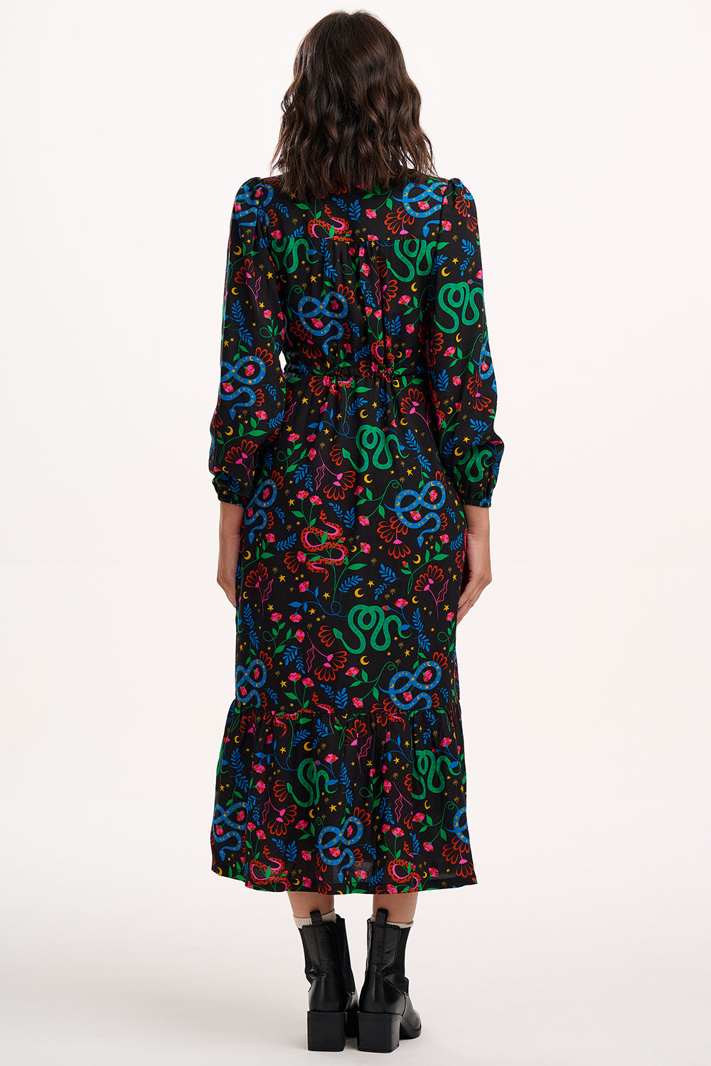 Woman wearing a colorful patterned dress on a white background