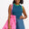 A woman wearing a sleeveless fitted vest top with blue and green stripes, paired with denim shorts and carrying a pink bag with stars.