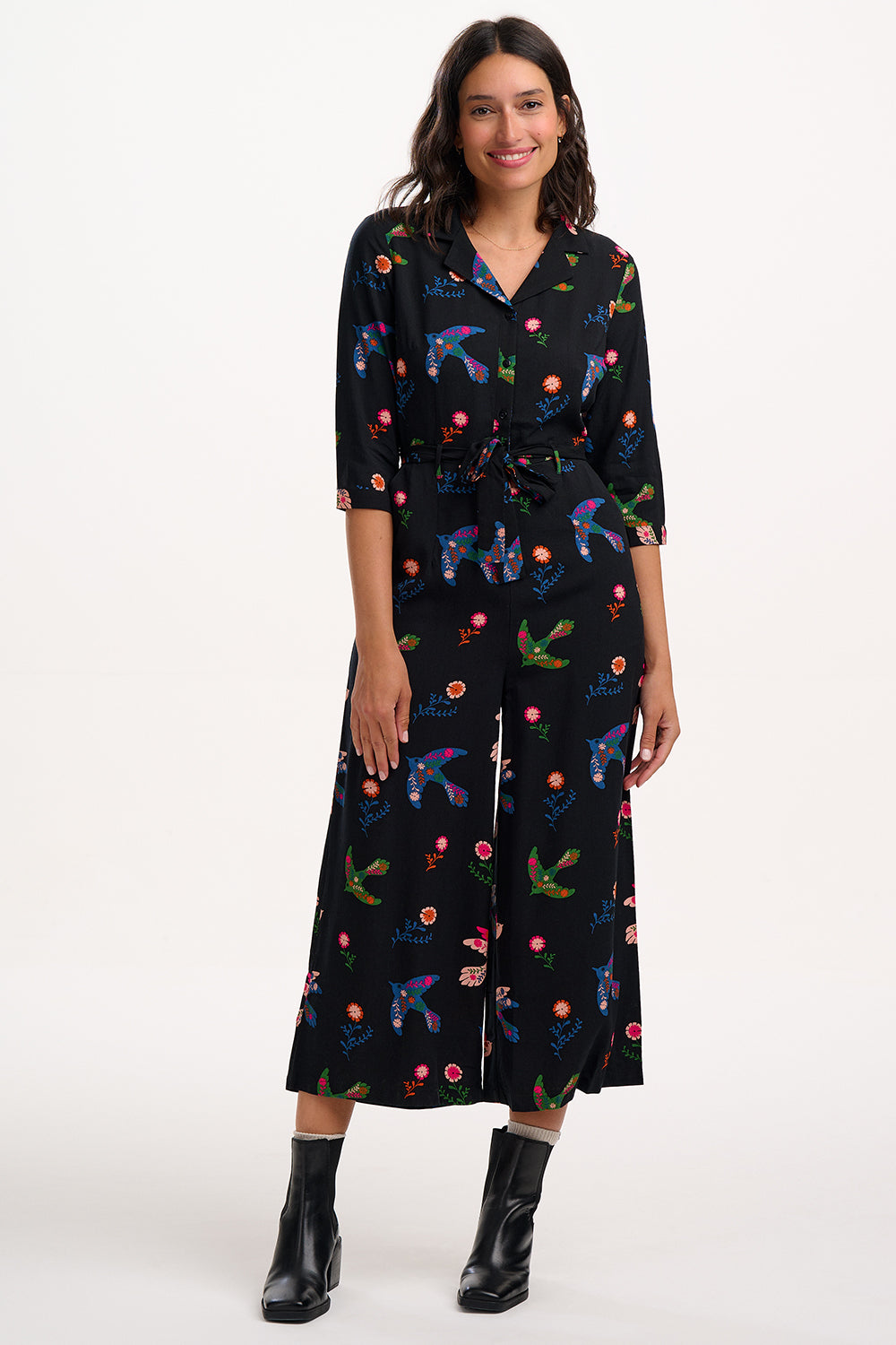 Woman wearing a black dress with colorful animal prints on a white background