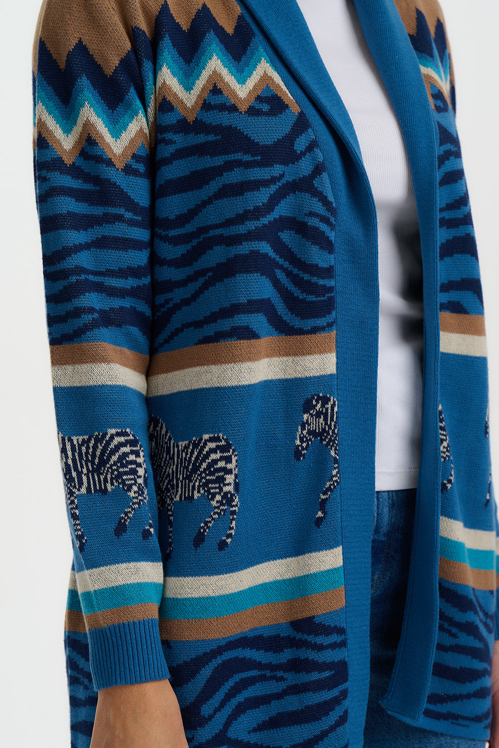 Blue cardigan with zebra and chevron patterns on a white background