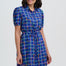 Woman wearing a blue checkered dress on a white background