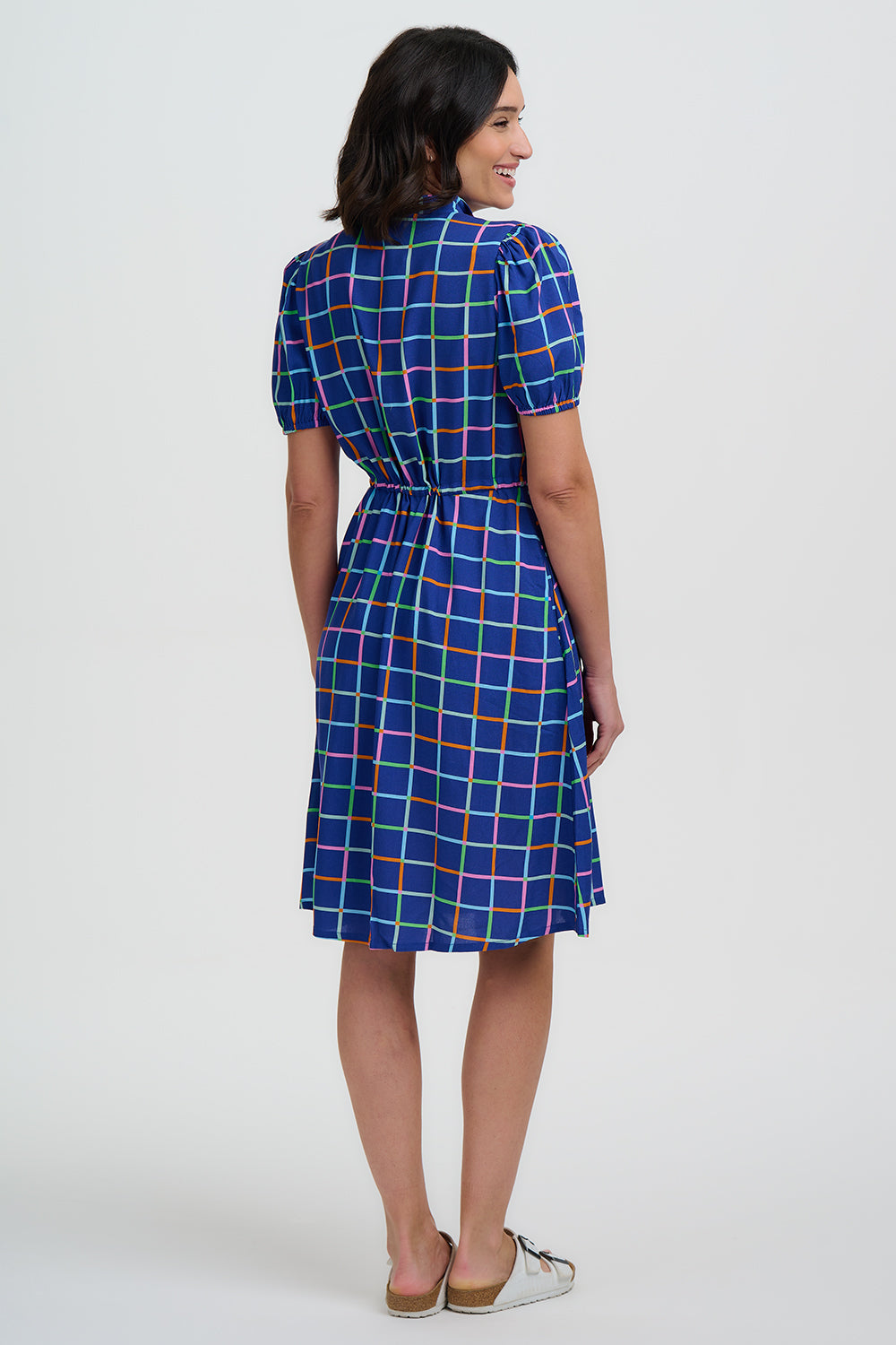 Woman wearing a blue checkered dress on a white background