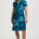 Woman wearing a blue dress with black patterns on a white background