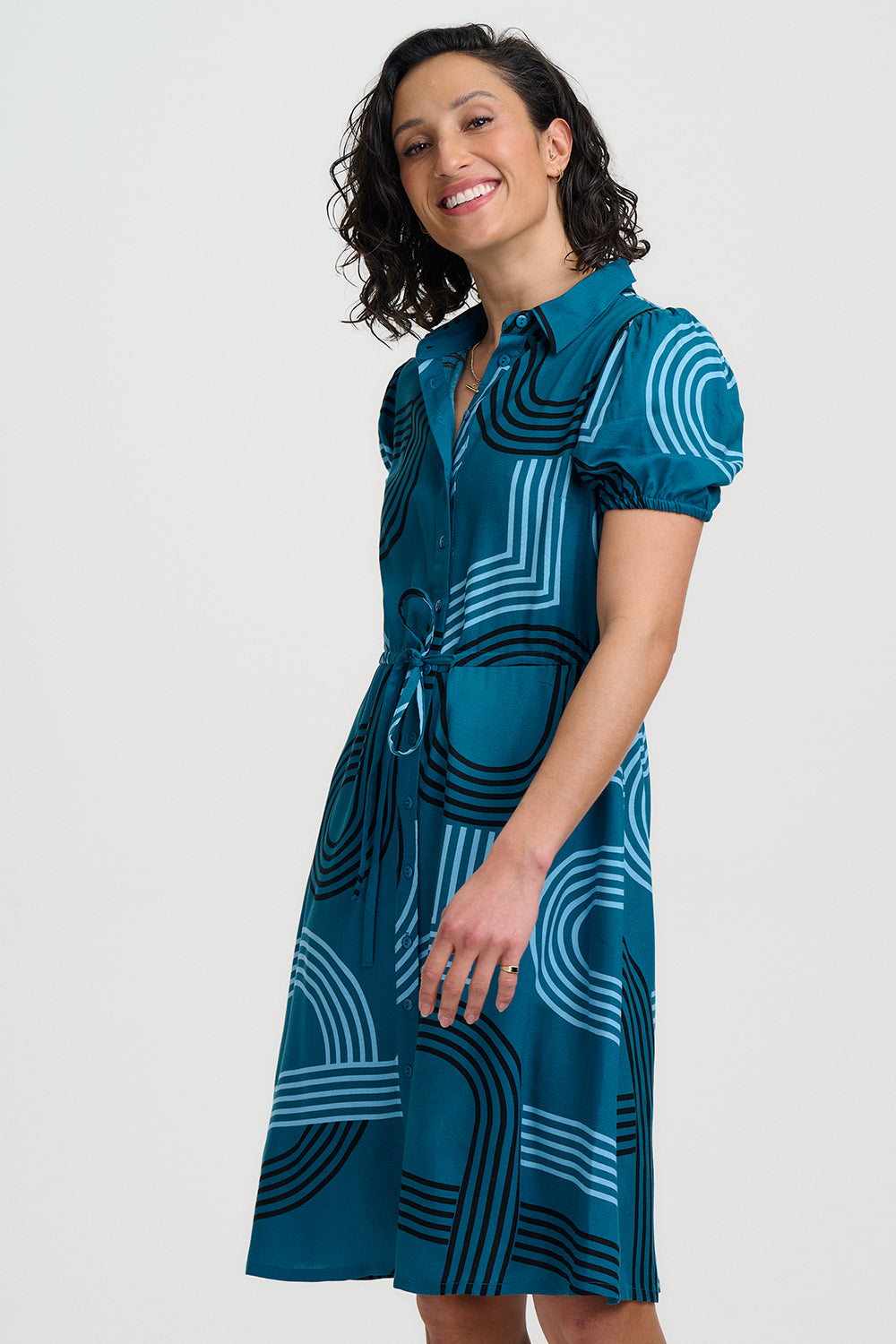 Woman wearing a blue dress with geometric pattern on a white background