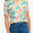 A woman wearing an off-white Santana shirt with a colorful jungle print, featuring short sleeves and a revere collar.