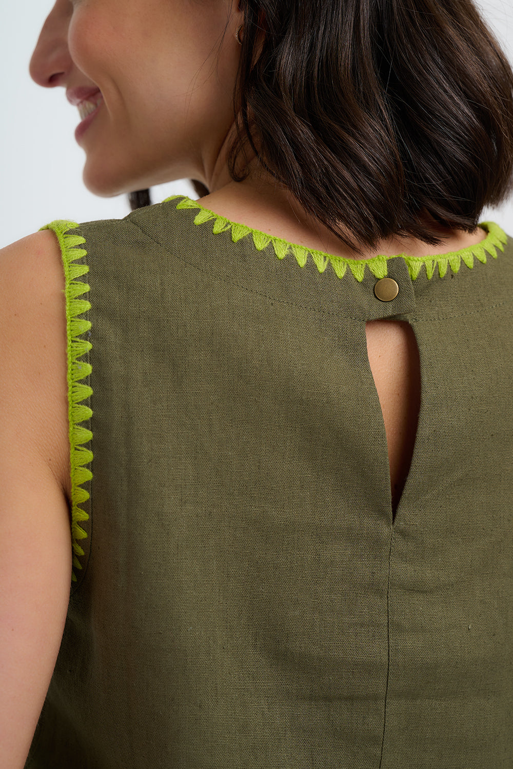 Green sleeveless top with lime green trim on a white background