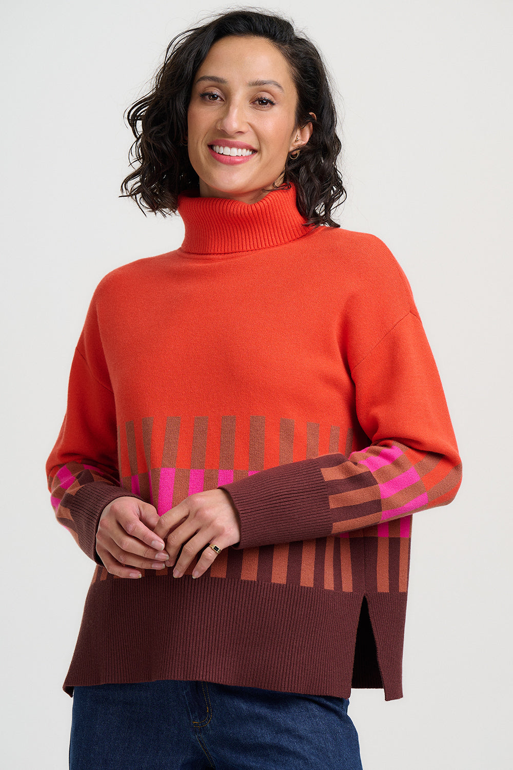 Woman wearing a red sweater with patterned sleeves on a white background