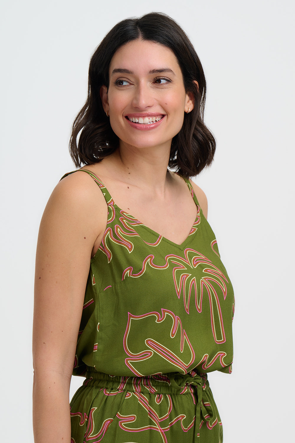 Woman wearing a green dress with red leaf pattern on a white background