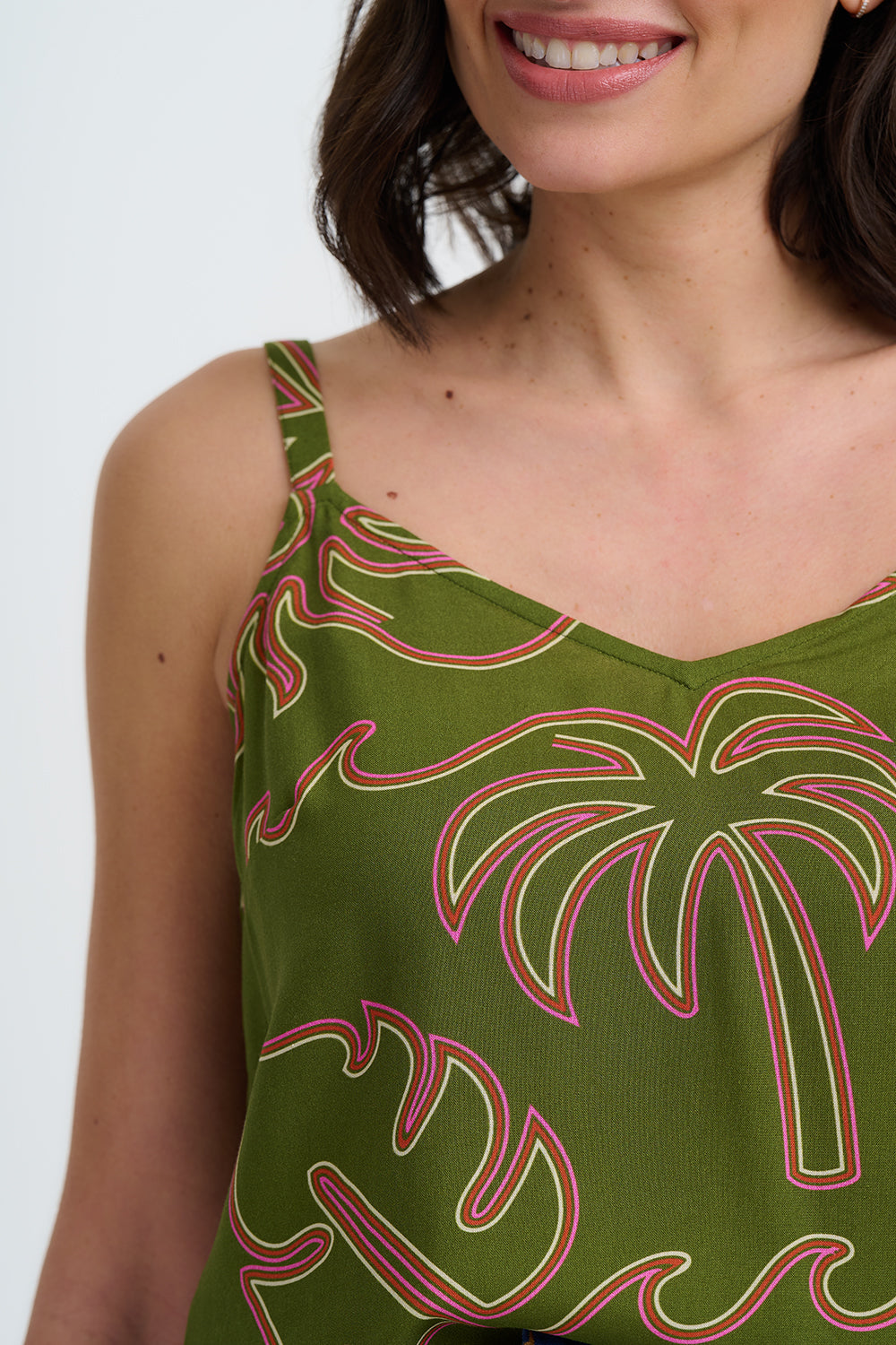 Woman wearing a green dress with palm tree pattern on a white background
