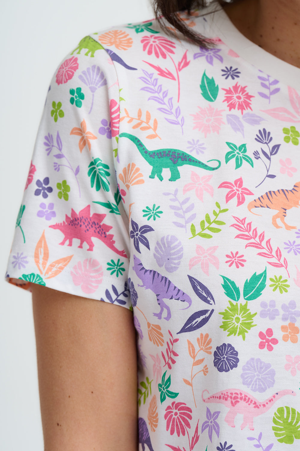 T-shirt with colorful dinosaur and floral pattern on a white background