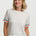 Woman wearing a white t-shirt with colorful sleeves against a plain background