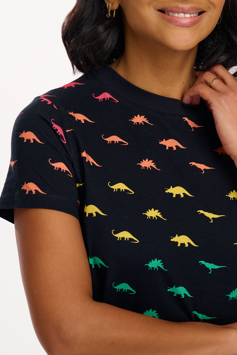 A woman wearing a black dress with colourful dinosaur pattern on a white background