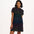 A woman wearing a black dress with colourful dinosaur pattern on a white background