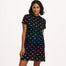 A woman wearing a black dress with colourful dinosaur pattern on a white background