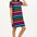 A model wearing a black and multicolored striped t-shirt dress with short sleeves.