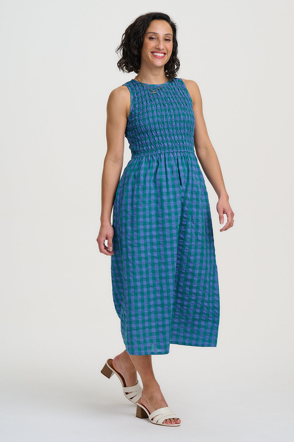 Woman wearing a blue checkered dress on a white background