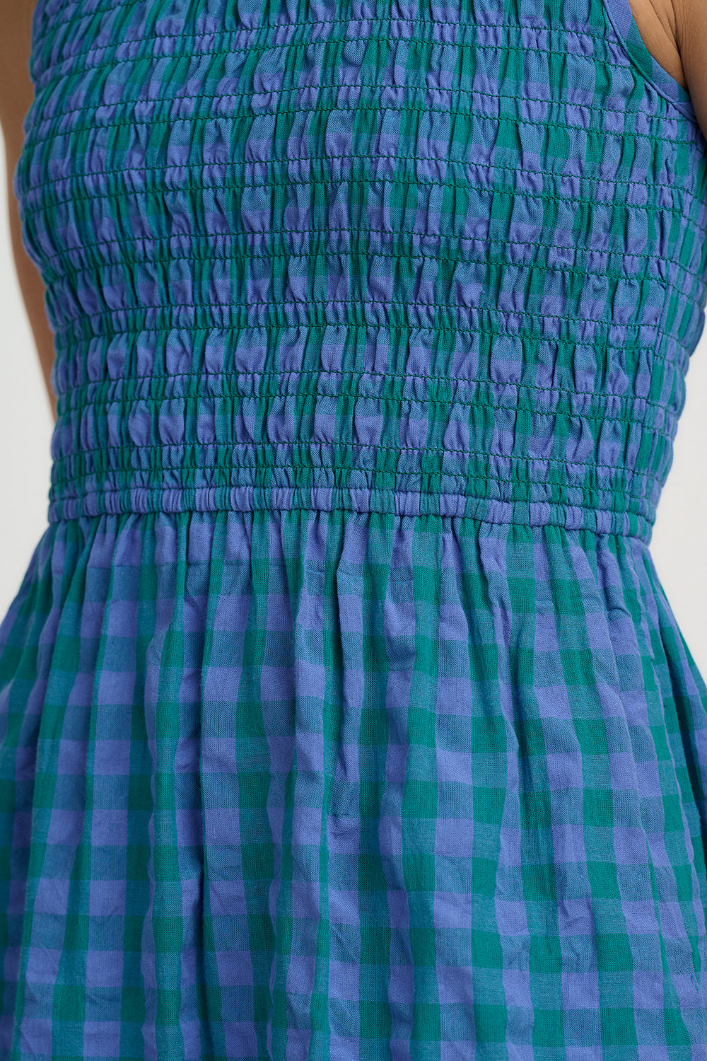 Green and blue checkered dress on a plain background