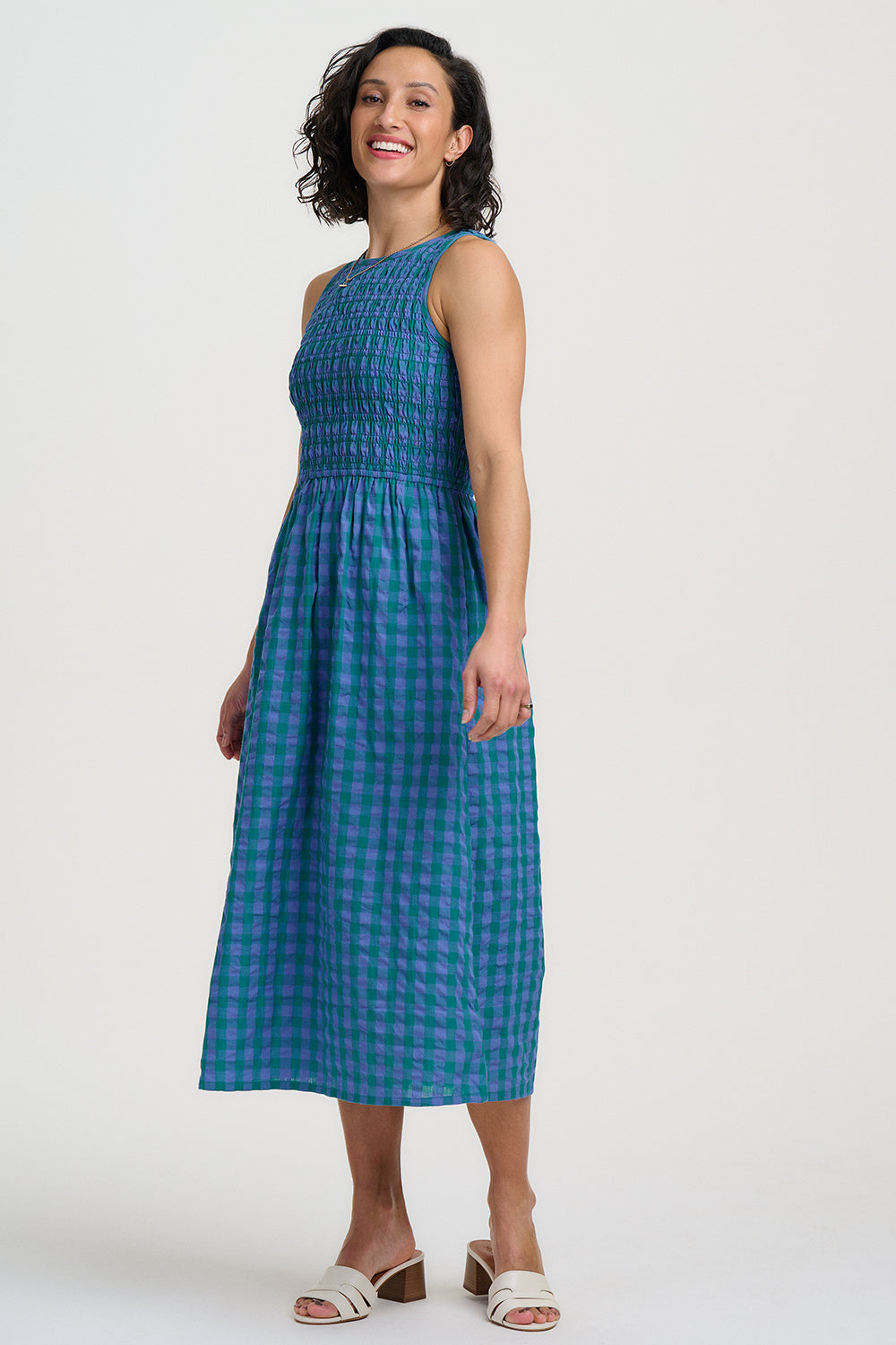Woman wearing a blue checkered dress against a white background