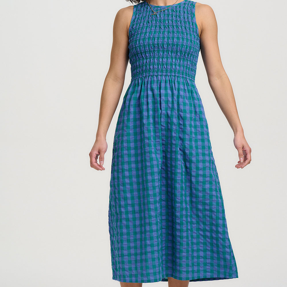 Woman wearing a blue checkered dress against a white background