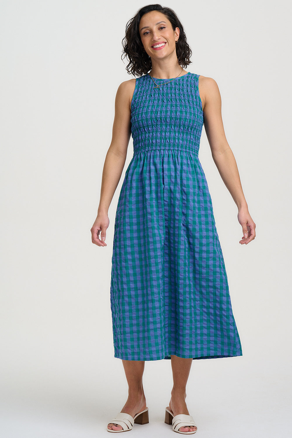 Woman wearing a blue checkered dress against a white background