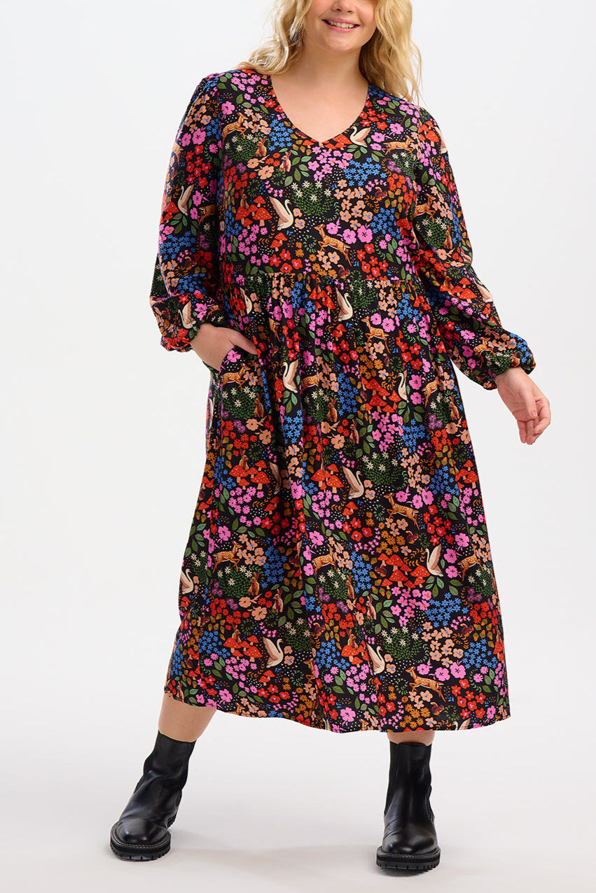 Woman wearing a colorful floral dress on a white background
