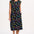 A model wearing a black midi dress with a colorful animal and floral print, standing against a white background.