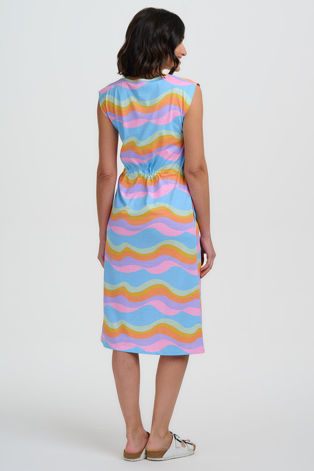 Woman wearing a colorful dress with wavy pattern on a white background