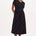 A model wearing a midi-length jersey cotton dress with a round neckline, elasticated waistband, short sleeves, and a pattern of undulating waves in black, red, and green.