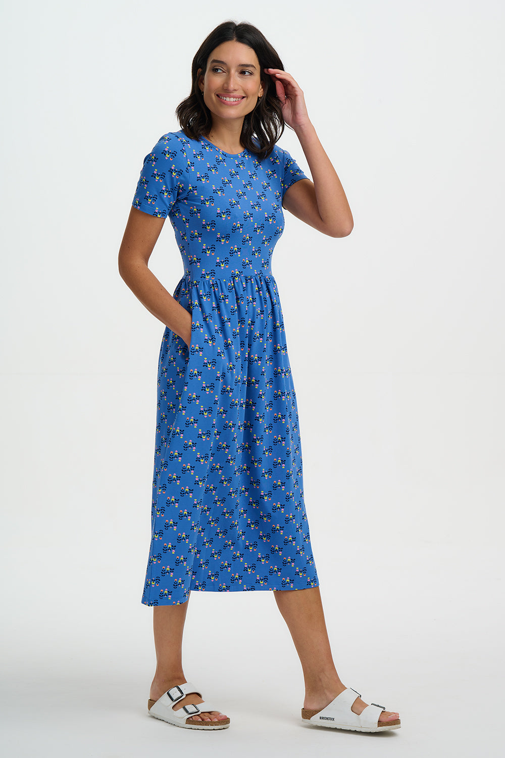 Woman wearing a blue dress with a pattern on a white background