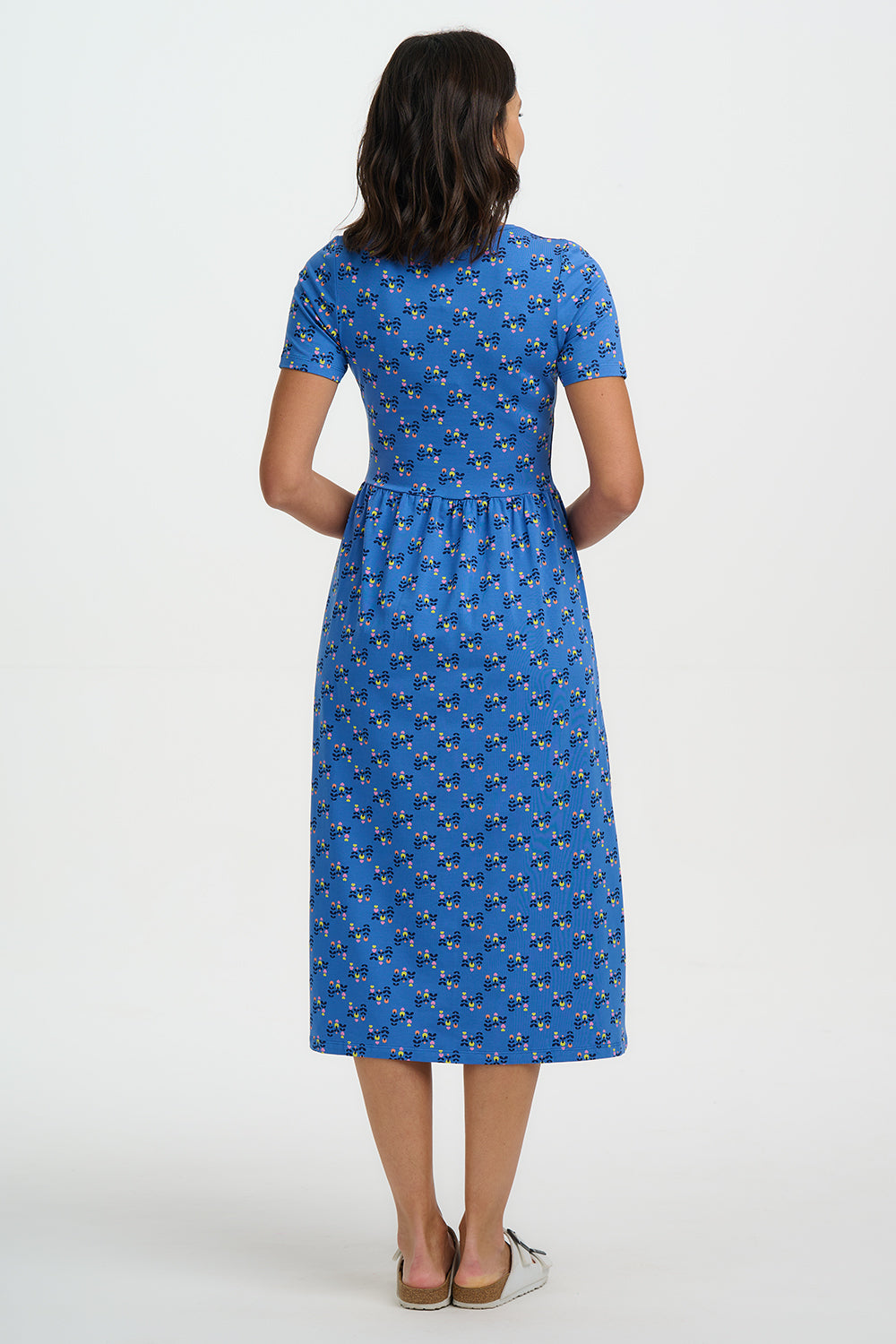 Woman wearing a blue dress with a pattern on a white background