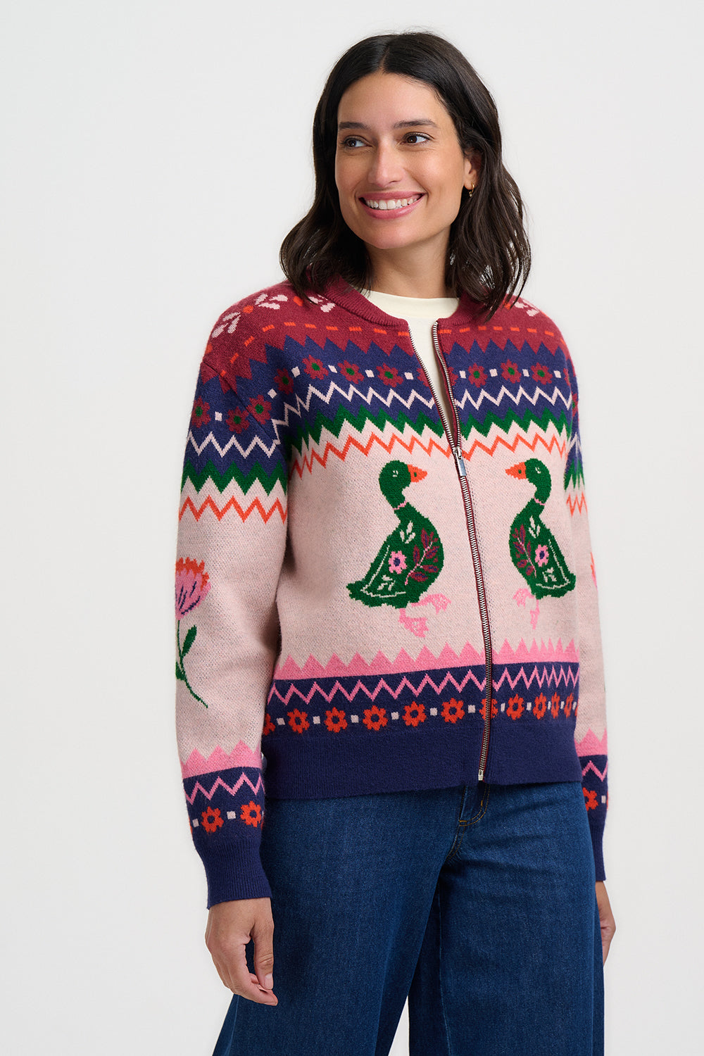 Woman wearing a colorful patterned sweater with a duck design on a white background