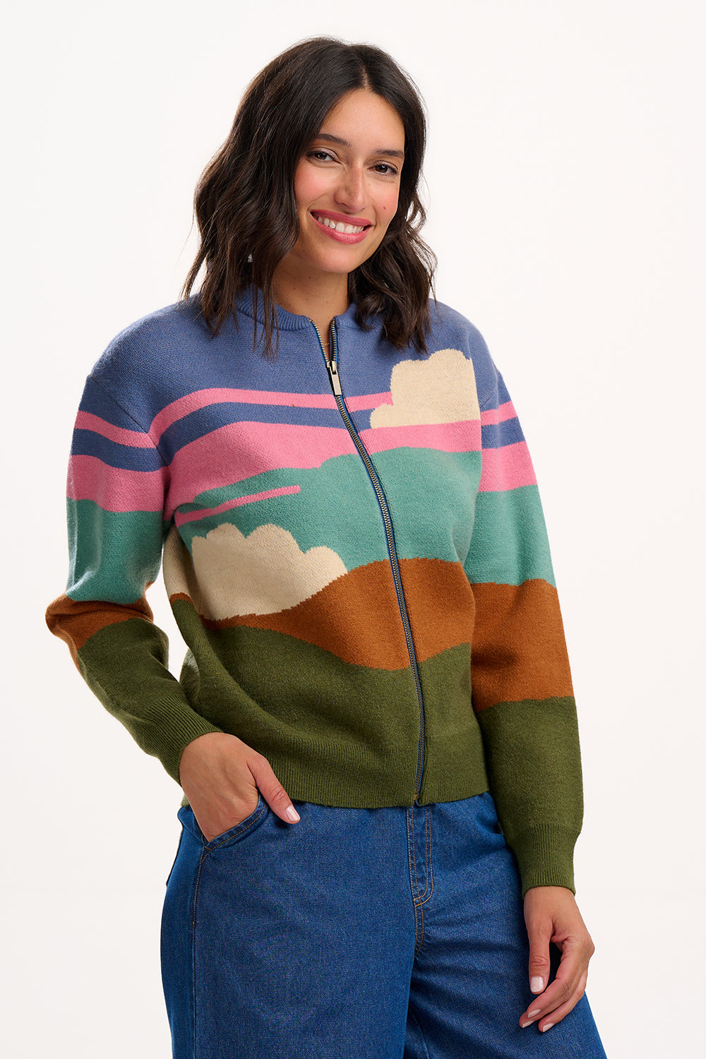 Woman wearing a colorful sweater with landscape design on a white background