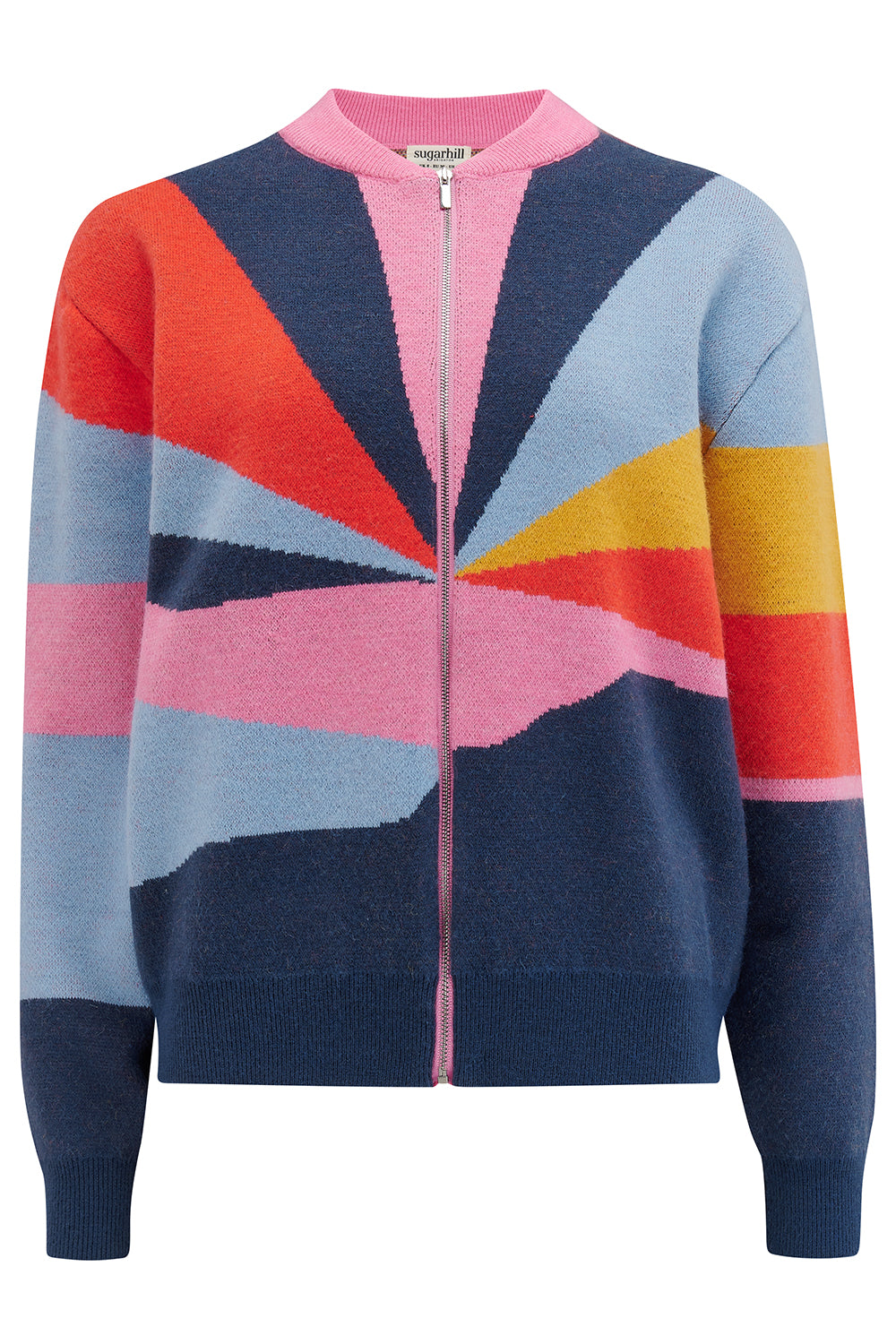 A woman wears a multicoloured knitted bomber jacket with a geometric pattern featuring shades of navy, blue, orange, pink, and mustard.
