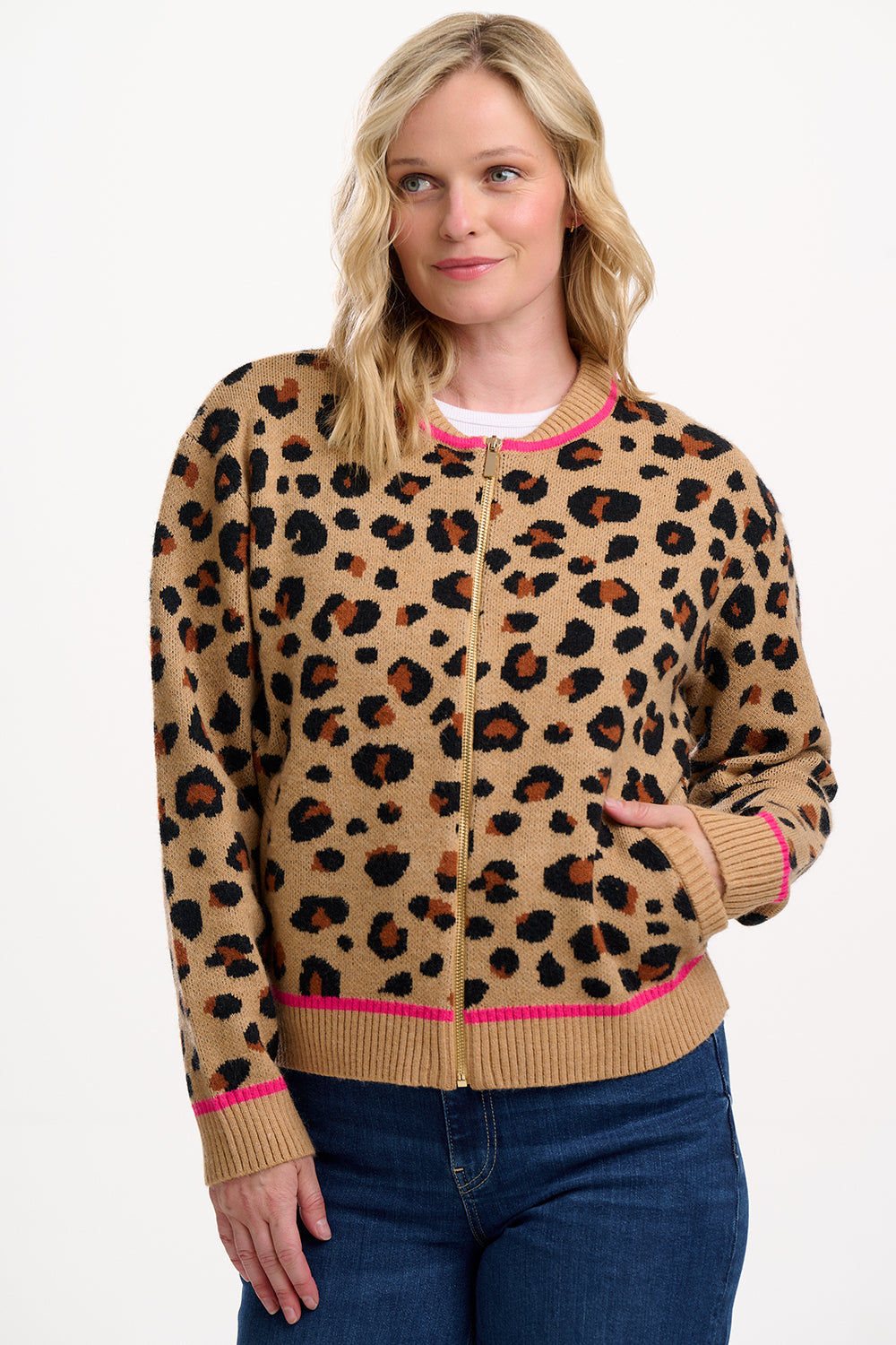 Woman wearing a leopard print cardigan with pink trim on a white background