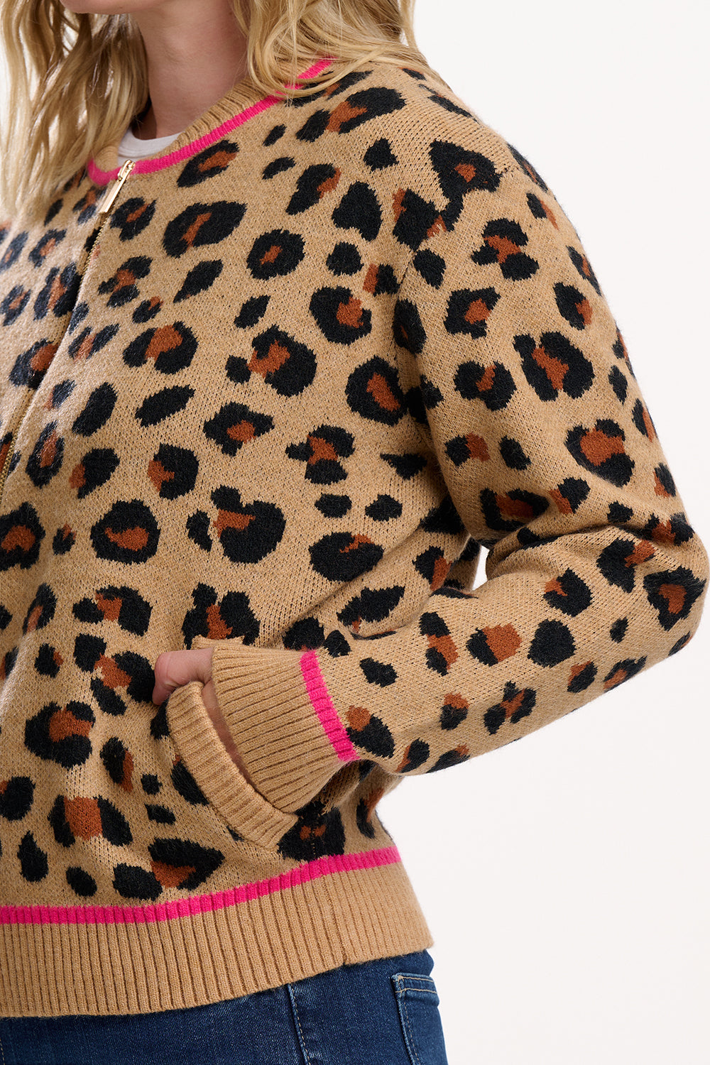 Leopard print sweater with pink accents worn by a person on a white background