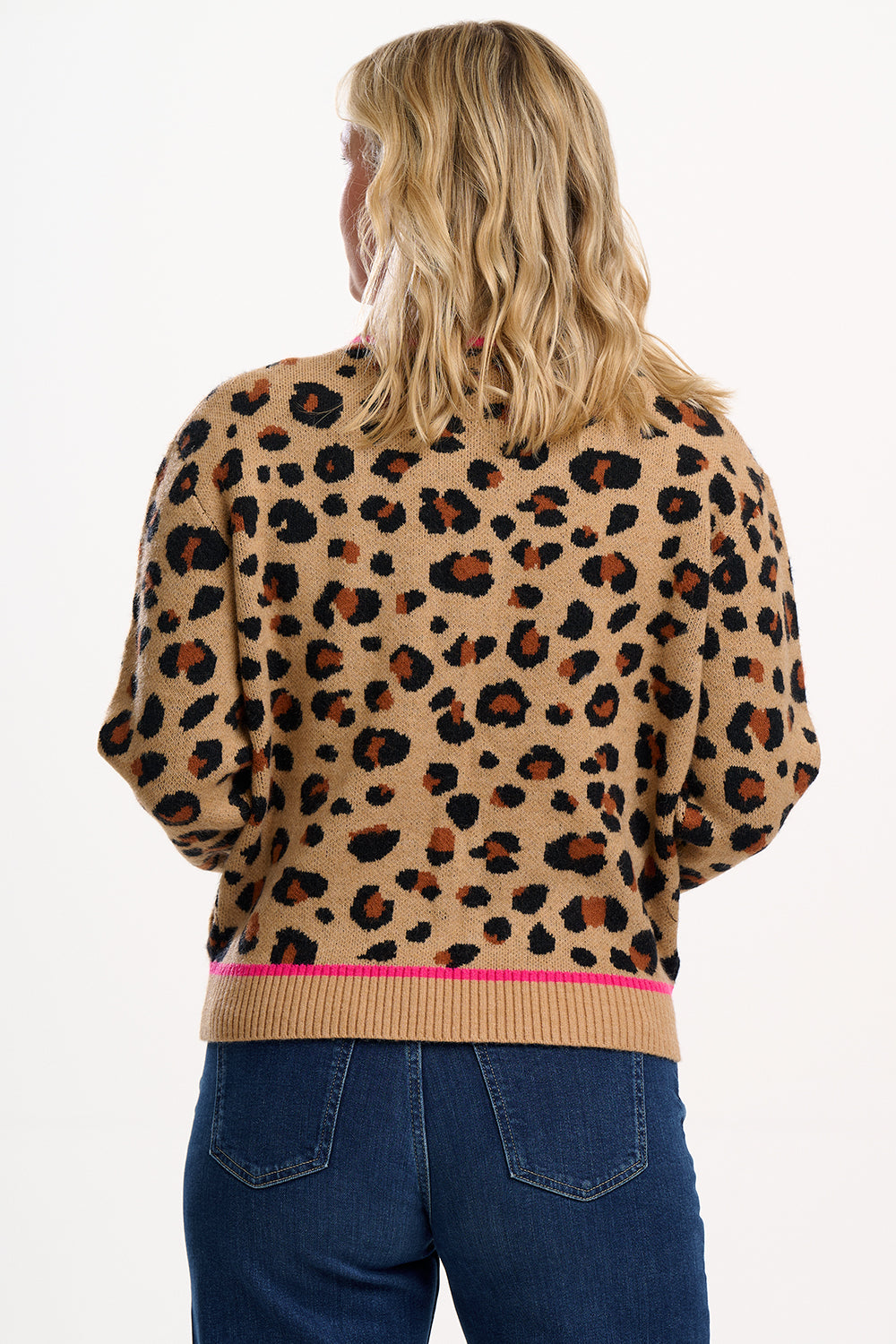 Person wearing a leopard print sweater with a plain background